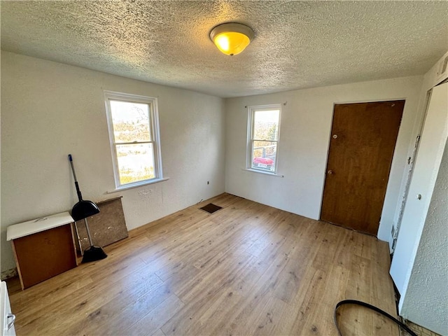 interior space featuring light hardwood / wood-style flooring and a textured ceiling