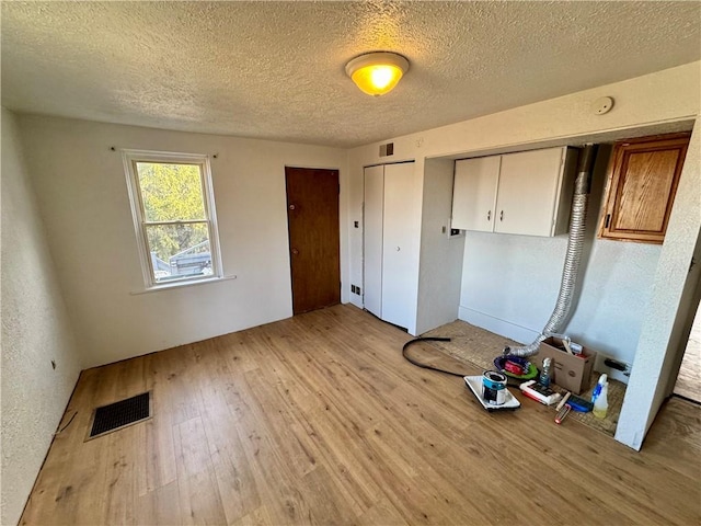 unfurnished bedroom featuring light hardwood / wood-style floors and a textured ceiling