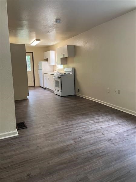 kitchen with dark hardwood / wood-style flooring and white appliances