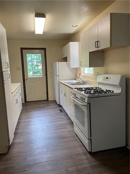 kitchen featuring white cabinets, dark hardwood / wood-style flooring, sink, and gas range gas stove