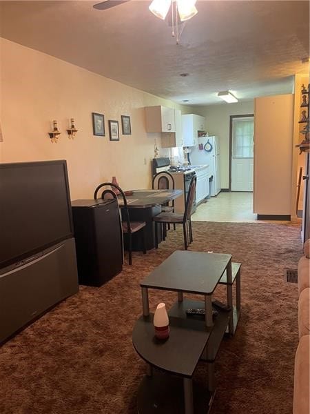 carpeted living room featuring ceiling fan