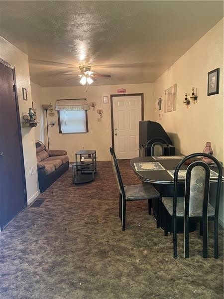 carpeted dining space with ceiling fan