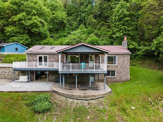 back of house with a lawn, a patio area, and a deck