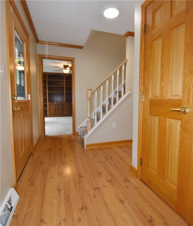 foyer entrance featuring ceiling fan, light hardwood / wood-style floors, and ornamental molding