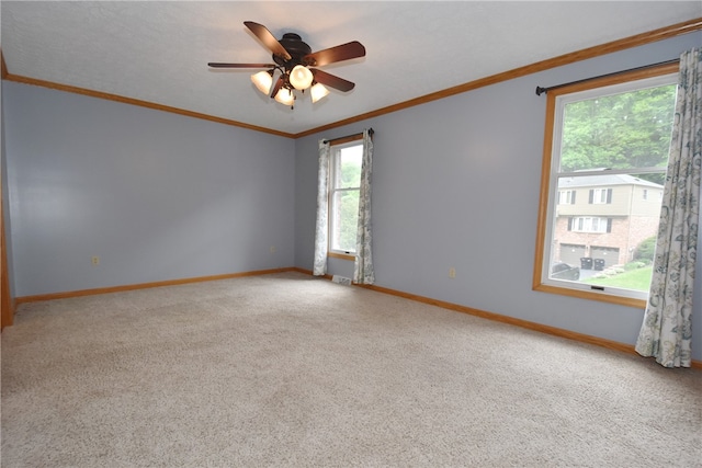 carpeted empty room with plenty of natural light, crown molding, and ceiling fan