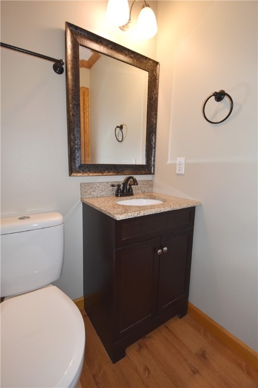 bathroom featuring hardwood / wood-style floors, vanity, and toilet