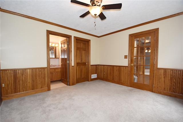 unfurnished room featuring light colored carpet, ceiling fan, and crown molding