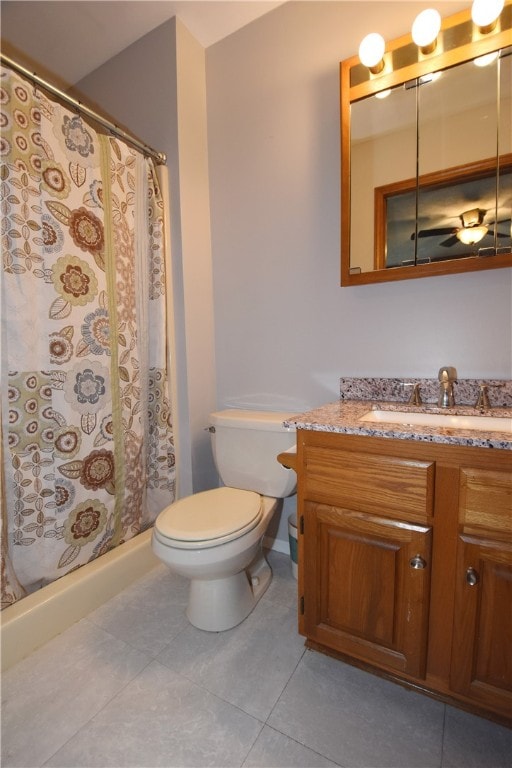 bathroom with curtained shower, toilet, tile floors, and vanity