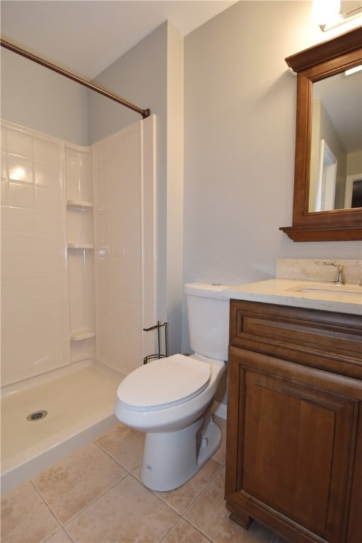 bathroom featuring walk in shower, vanity, toilet, and tile floors