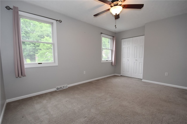 empty room with ceiling fan and carpet