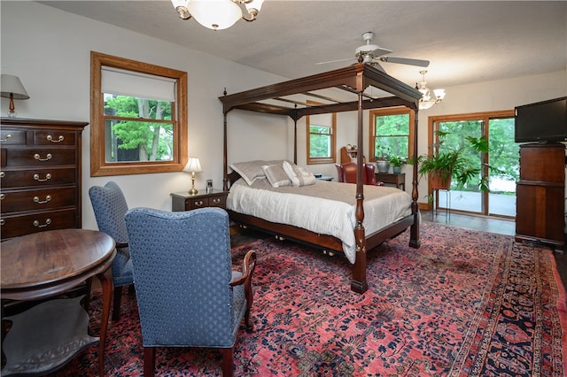 bedroom with ceiling fan with notable chandelier and access to outside