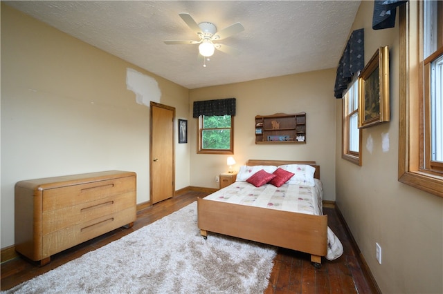 bedroom featuring wood-type flooring, ceiling fan, and a textured ceiling