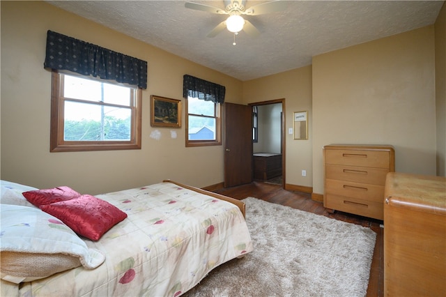 bedroom with a textured ceiling, hardwood / wood-style floors, and ceiling fan