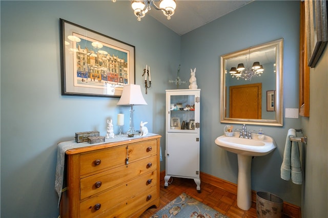 bathroom featuring parquet flooring, sink, and an inviting chandelier