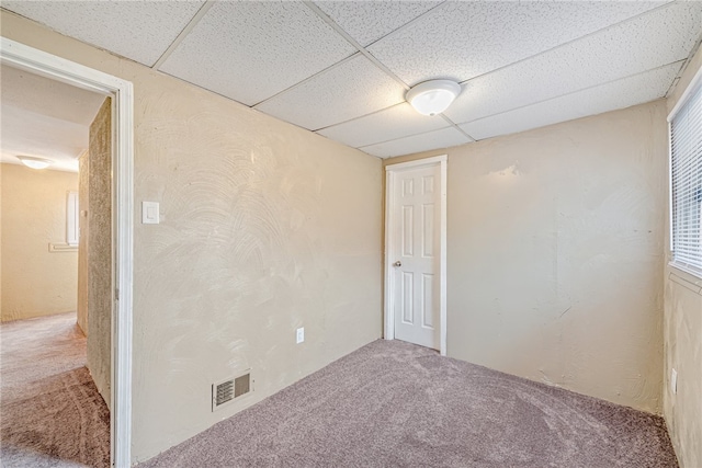 unfurnished room with carpet floors and a paneled ceiling