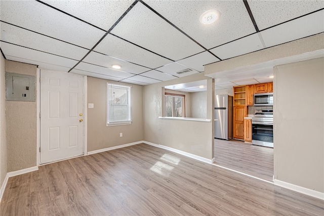 unfurnished room featuring light hardwood / wood-style flooring and a drop ceiling