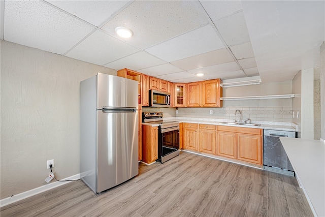 kitchen with a drop ceiling, light hardwood / wood-style floors, and stainless steel appliances