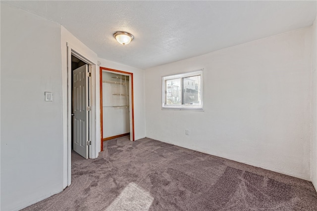 unfurnished bedroom featuring carpet, a closet, and a textured ceiling