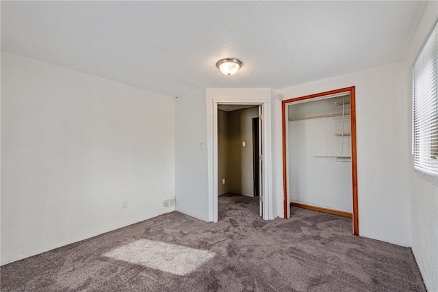 unfurnished bedroom featuring carpet, multiple windows, and a closet