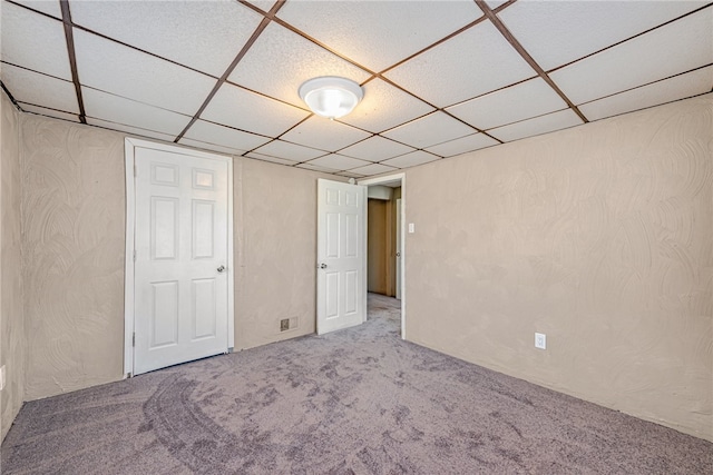 unfurnished bedroom with carpet floors and a drop ceiling