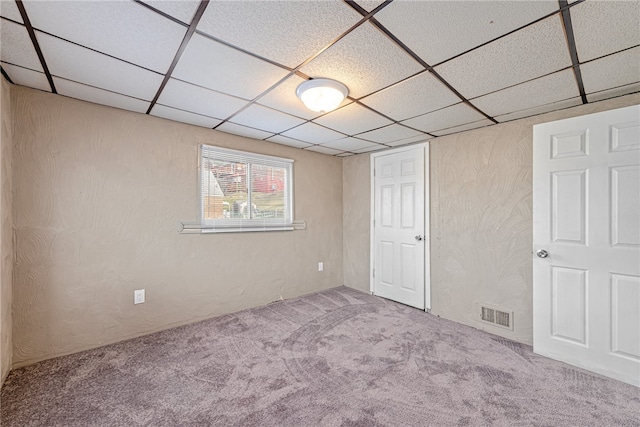 unfurnished bedroom with carpet flooring and a drop ceiling