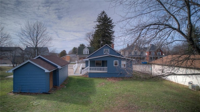 rear view of property featuring central AC, a porch, and a yard