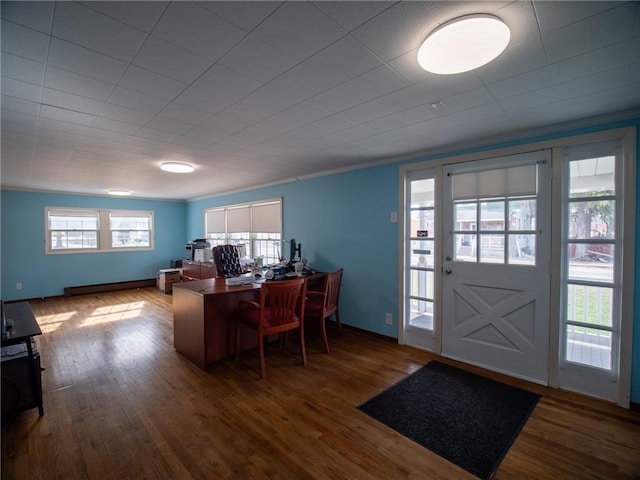 office area featuring crown molding, a baseboard heating unit, and dark hardwood / wood-style flooring