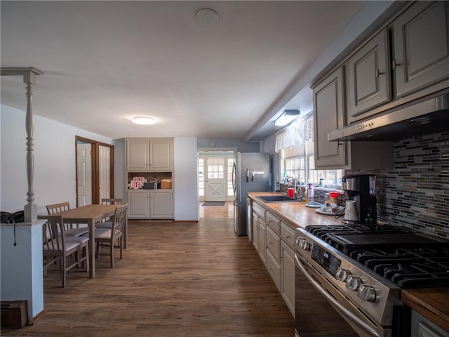 kitchen with stainless steel appliances, sink, dark hardwood / wood-style flooring, and decorative backsplash