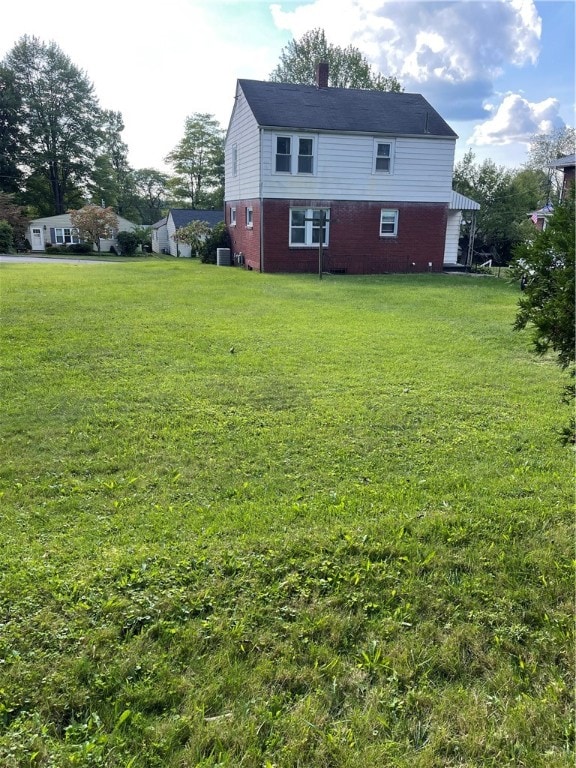 rear view of house featuring a lawn