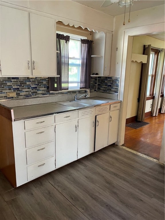 kitchen featuring sink, white cabinetry, dark hardwood / wood-style floors, and backsplash