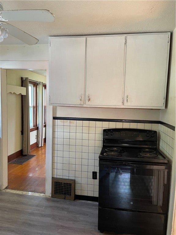 room details featuring hardwood / wood-style floors, electric range, ceiling fan, and a textured ceiling