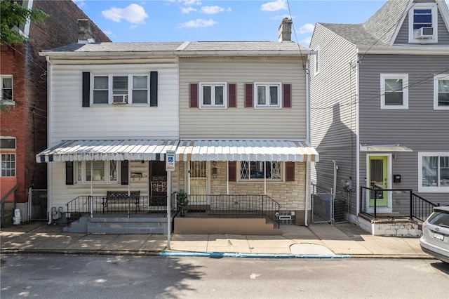 view of property featuring a porch and central AC unit