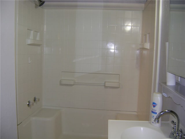 bathroom featuring tiled shower / bath combo and sink