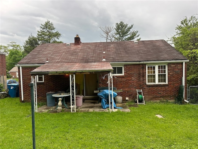 back of property featuring a patio area and a yard