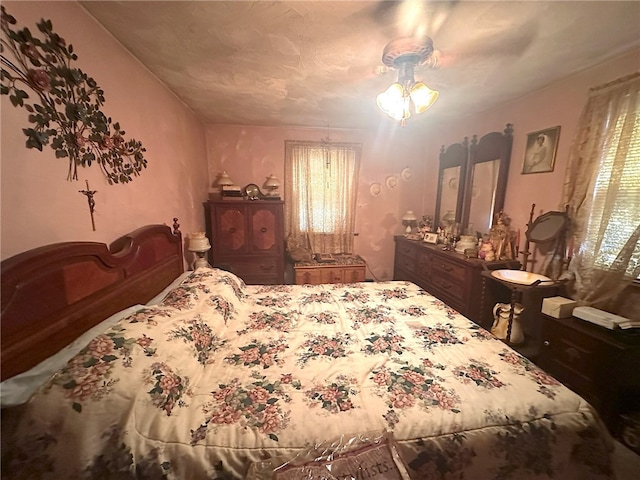 bedroom featuring ceiling fan and multiple windows