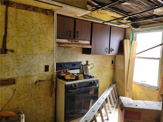 kitchen with dark brown cabinets, custom range hood, and white range with gas cooktop