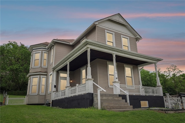 view of front of property featuring covered porch and a lawn