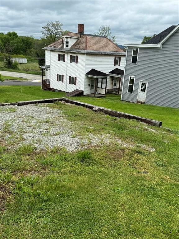 rear view of property with a lawn