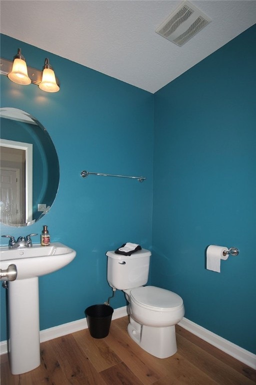 bathroom featuring wood-type flooring and toilet