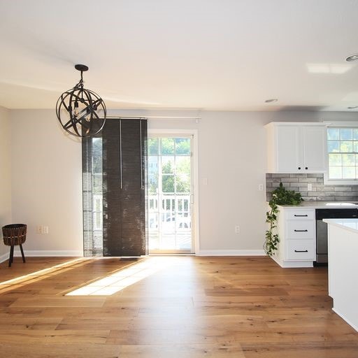 kitchen with dishwasher, plenty of natural light, light hardwood / wood-style floors, and white cabinetry