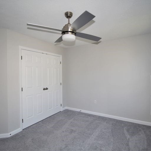 unfurnished bedroom featuring carpet, ceiling fan, and a closet