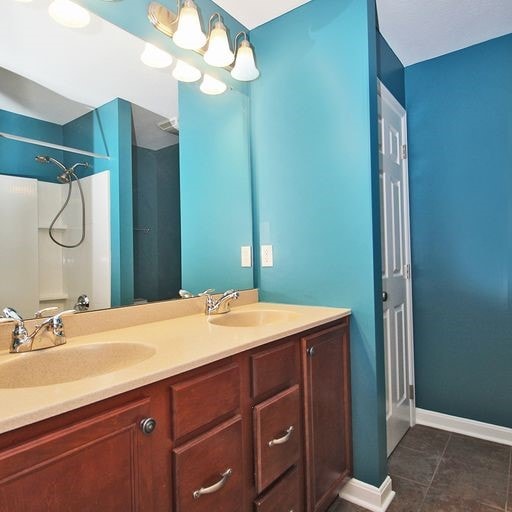 bathroom featuring tile flooring and dual bowl vanity