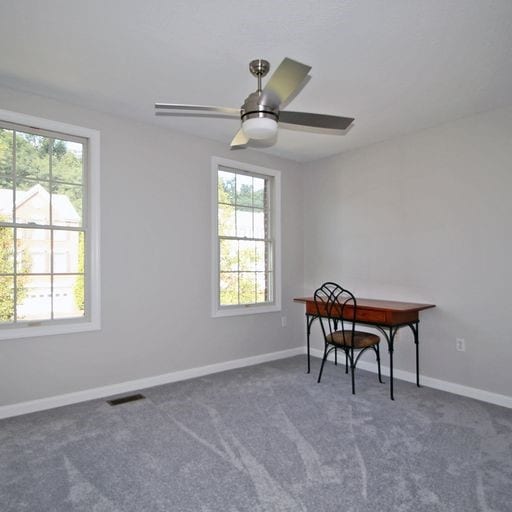 carpeted office space with ceiling fan