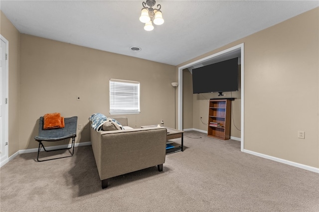 carpeted living room with a chandelier