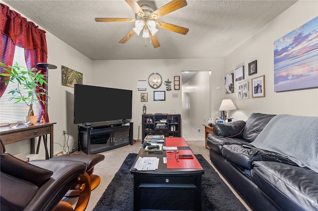 living room featuring ceiling fan, carpet floors, and a textured ceiling