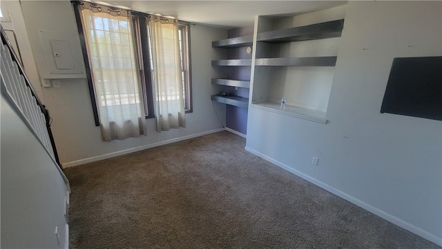 spare room with dark carpet and a wealth of natural light