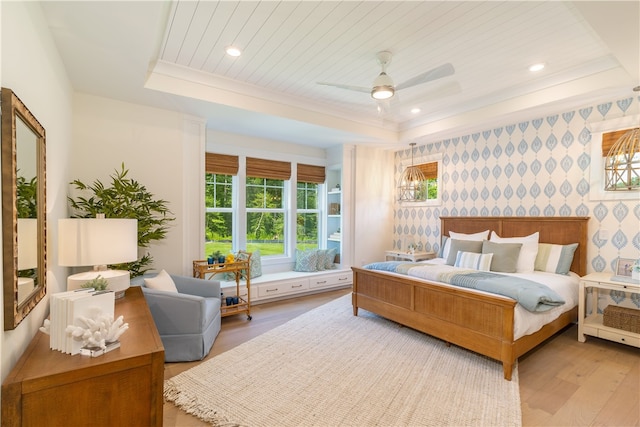 bedroom featuring hardwood / wood-style flooring, ceiling fan, and a raised ceiling