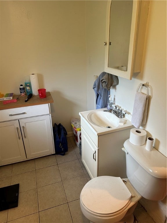 bathroom with vanity, toilet, and tile floors