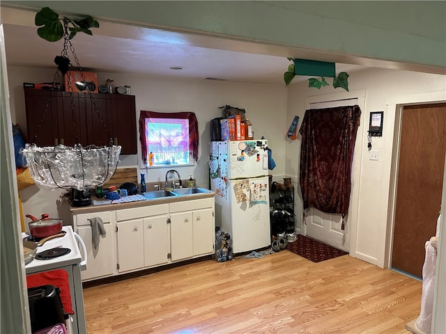 kitchen with sink, light hardwood / wood-style floors, white appliances, and white cabinetry