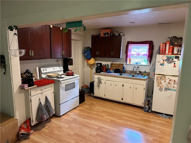 kitchen with white appliances, sink, and light hardwood / wood-style floors